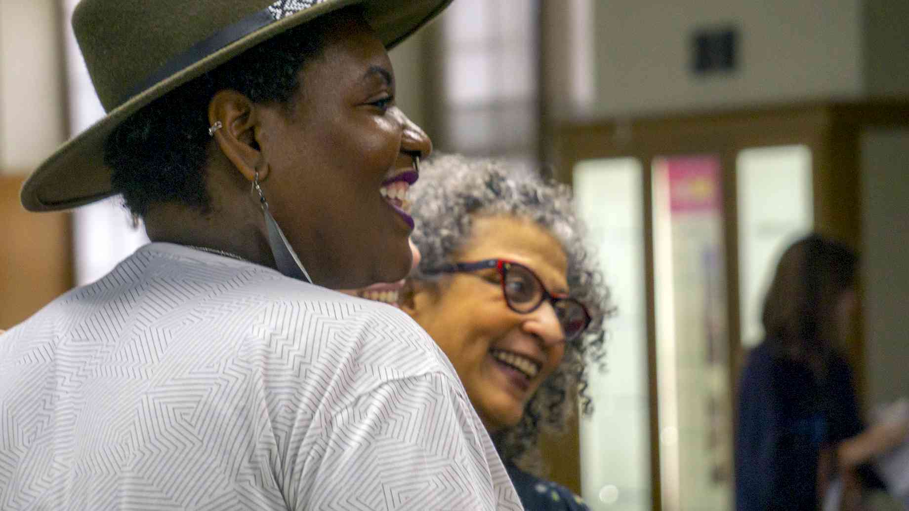 Program Department Head Porchia Moore and Joanne Jones-Rizzi of the Science Museum of Minnesota. [Alt text: Two laughing women looking to the right.]